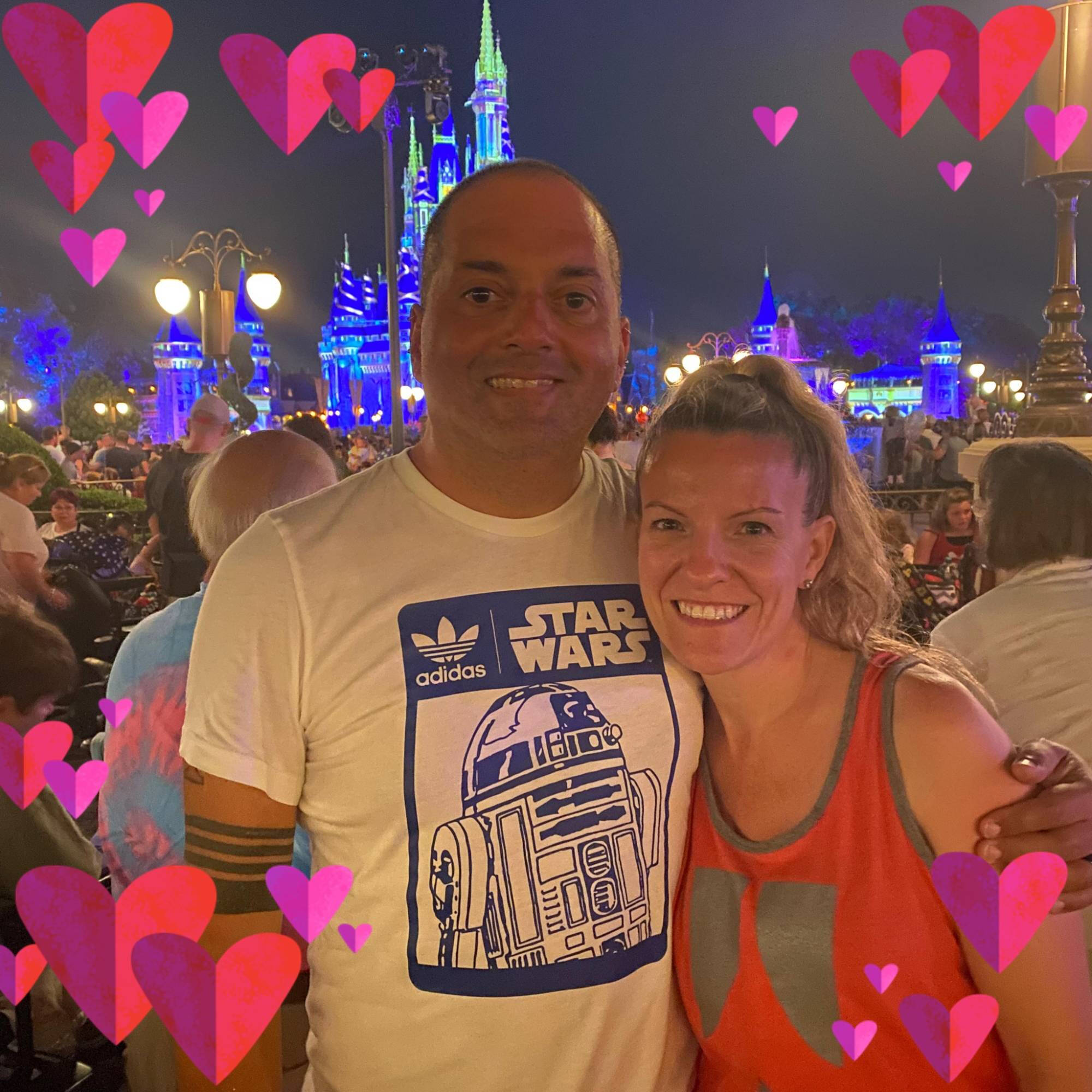 Will Gordillo wearing a white Star Wars t-shirt with an R2D2 on it. His arm is wrapped around a woman.